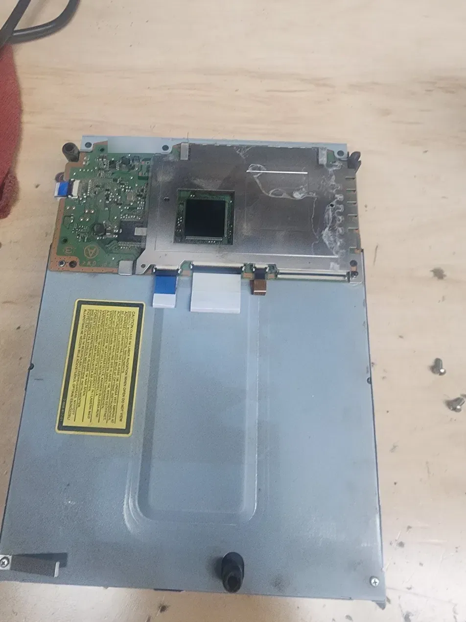 White dried soda residue smeared across the metal shield on the PS3 Blu-ray drive controller board