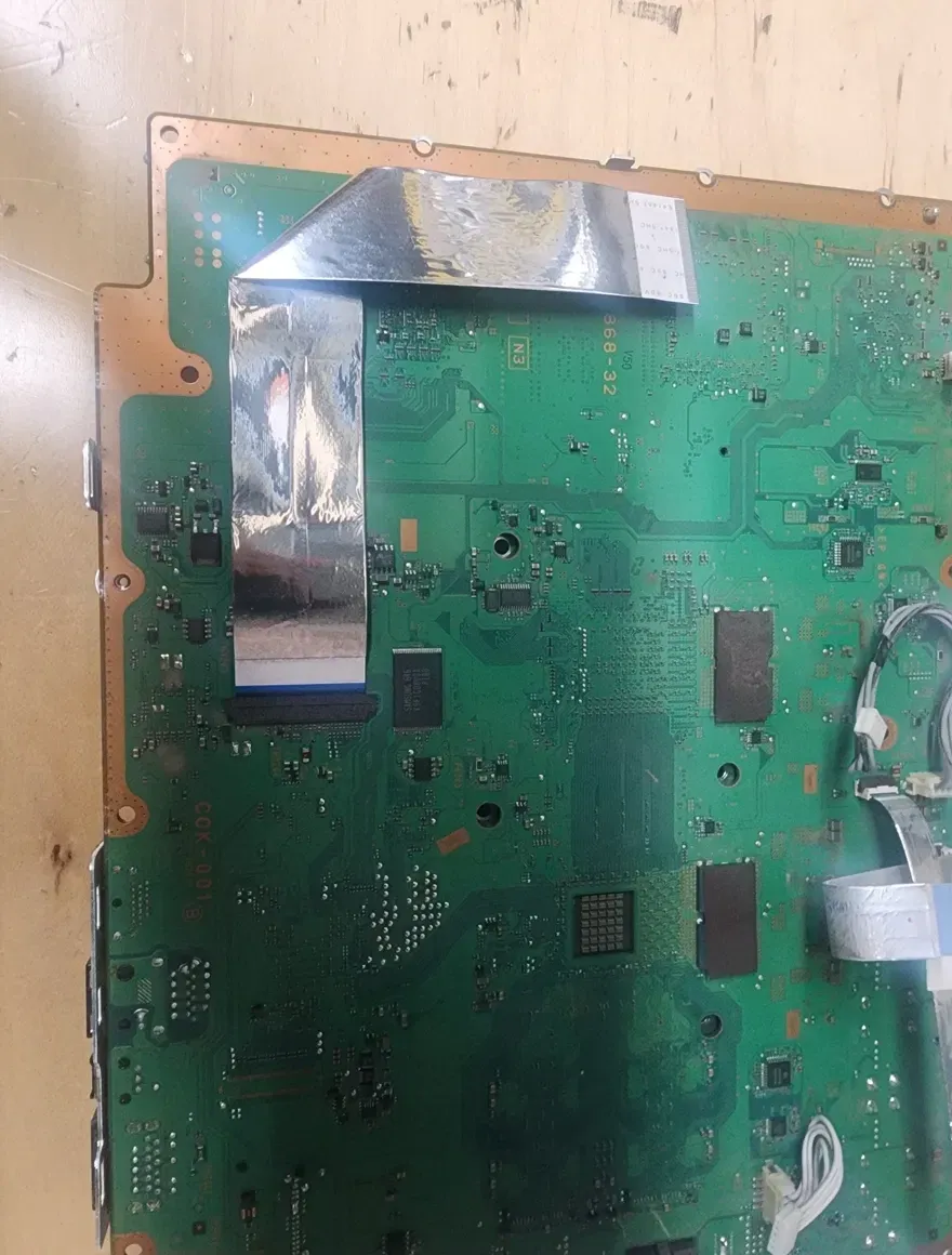 Underside of the PS3 COK-001 motherboard with ribbon cables still attached